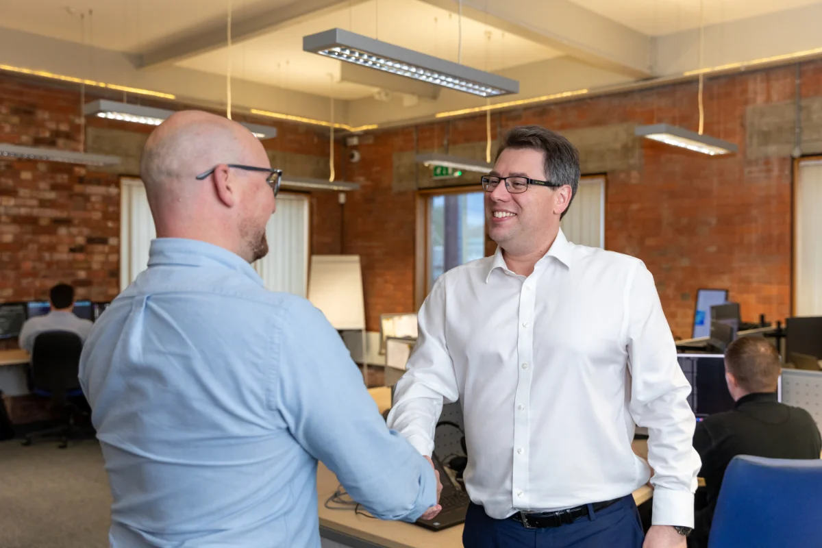 Director Chris shaking hands with prospect in Syscomm office, Coventry