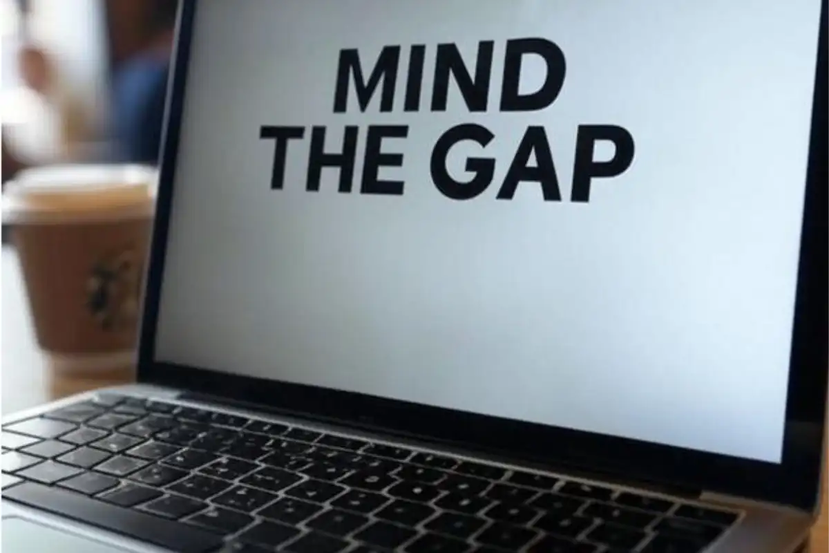laptop in coffee shop with plain screen that reads mind the gap