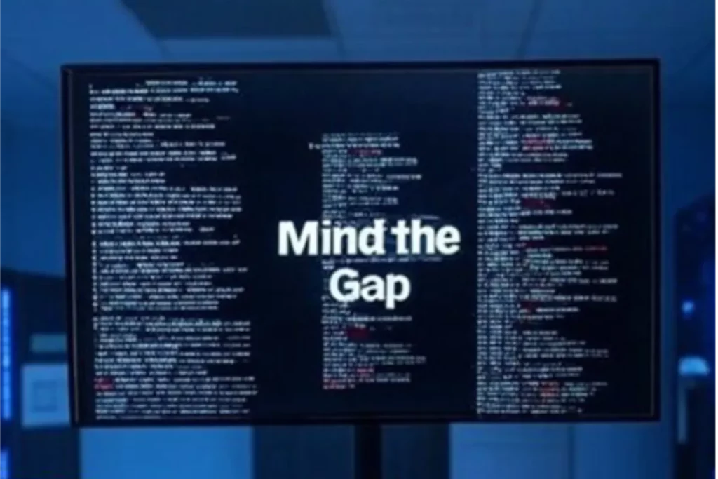 screen in data centre with code running on it with text in the middle that says mind the gap