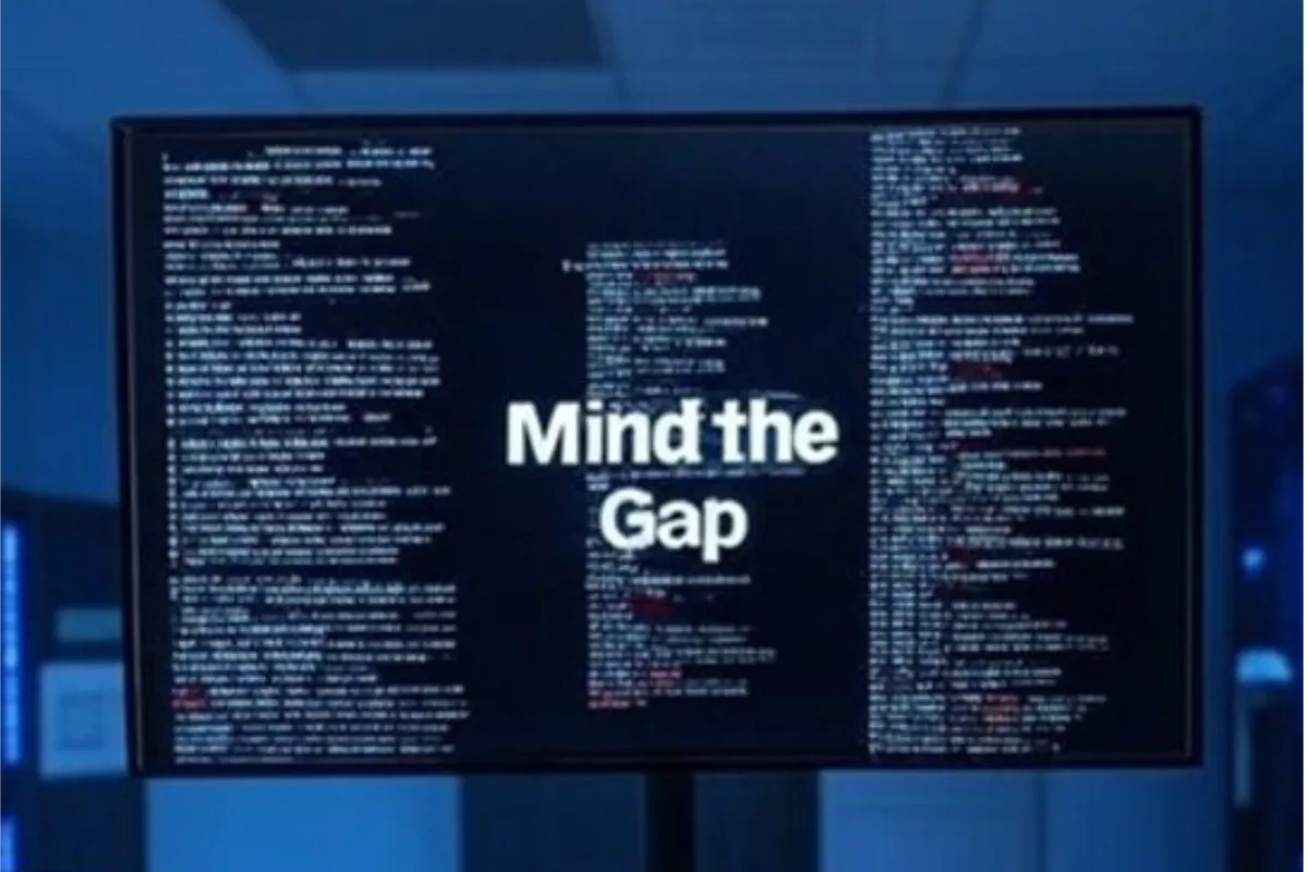 screen in data centre with code running on it with text in the middle that says mind the gap