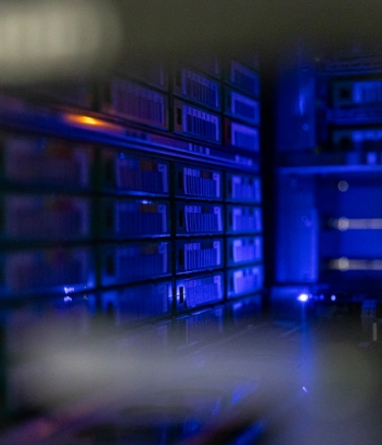 Close-up of a data server rack illuminated by blue LED lighting
