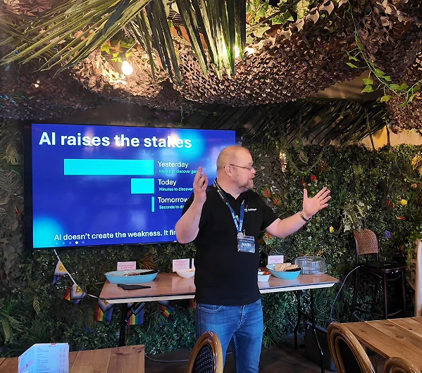 Mark Wainwright explaining how AI raises the stakes, with a slide comparing attack speed yesterday, today and tomorrow