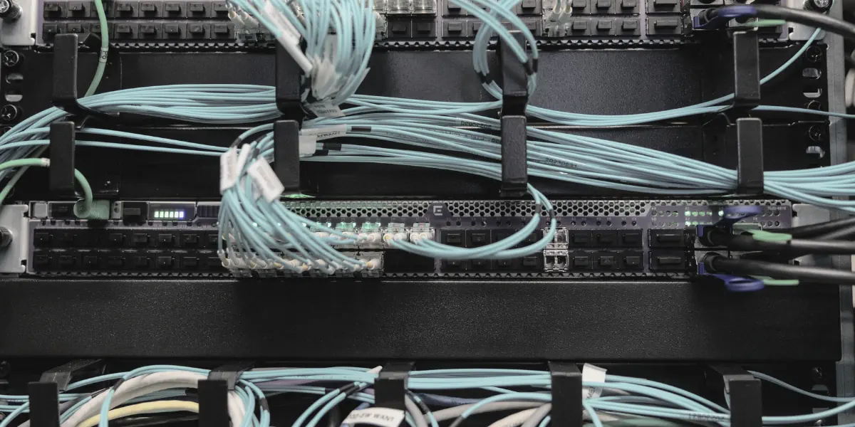 Fibre optic patch cables connected to a network switch in a data centre rack