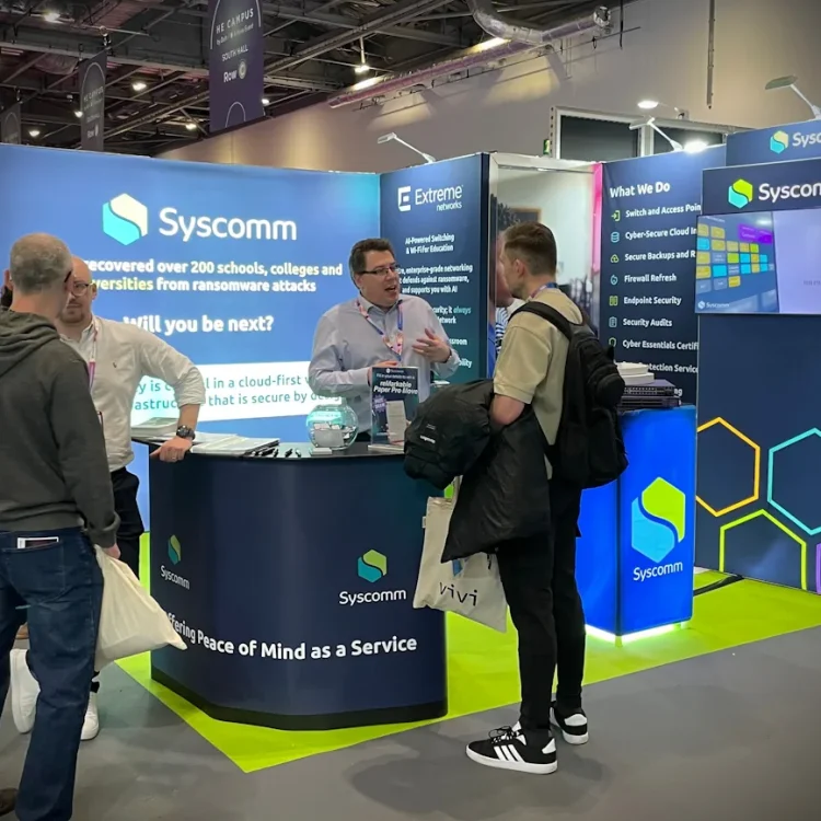 Chris Tyler, Syscomm Director, talking with visitors at the Syscomm stand at Bett 2026